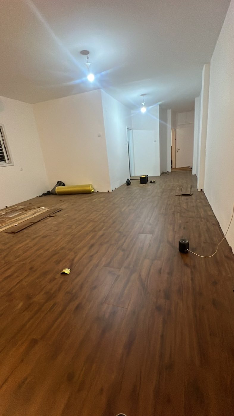 אותו סלון לאחר שיפוץ – ריצוף פרקט חדש, קירות צבועים ותאורה שקועה