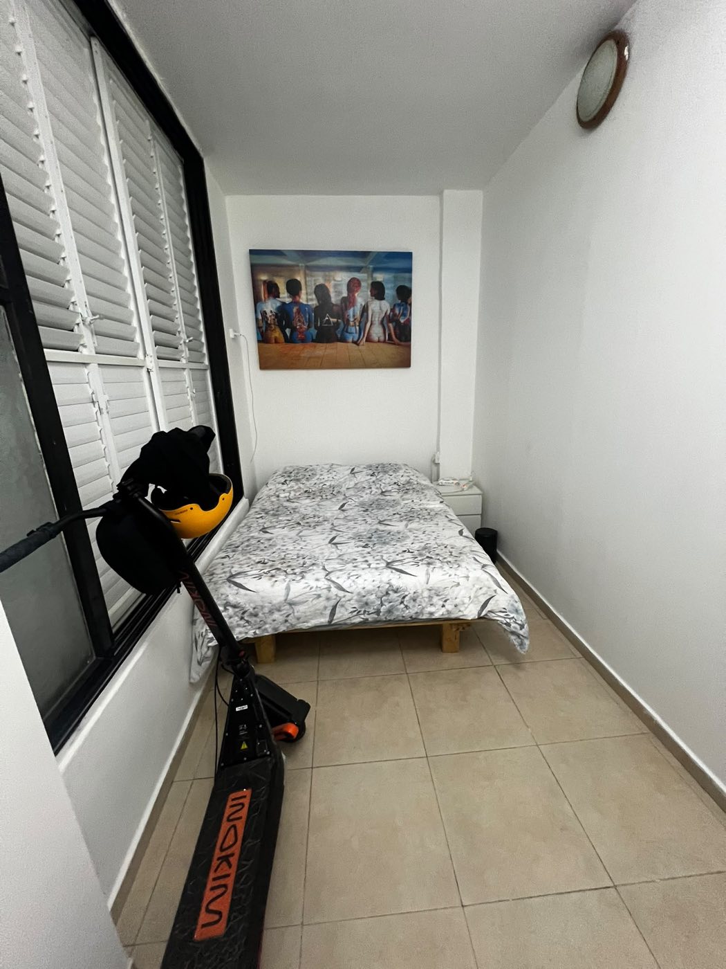 חדר שינה מוגמר עם קירות לבנים, ריצוף נקי ומיטה